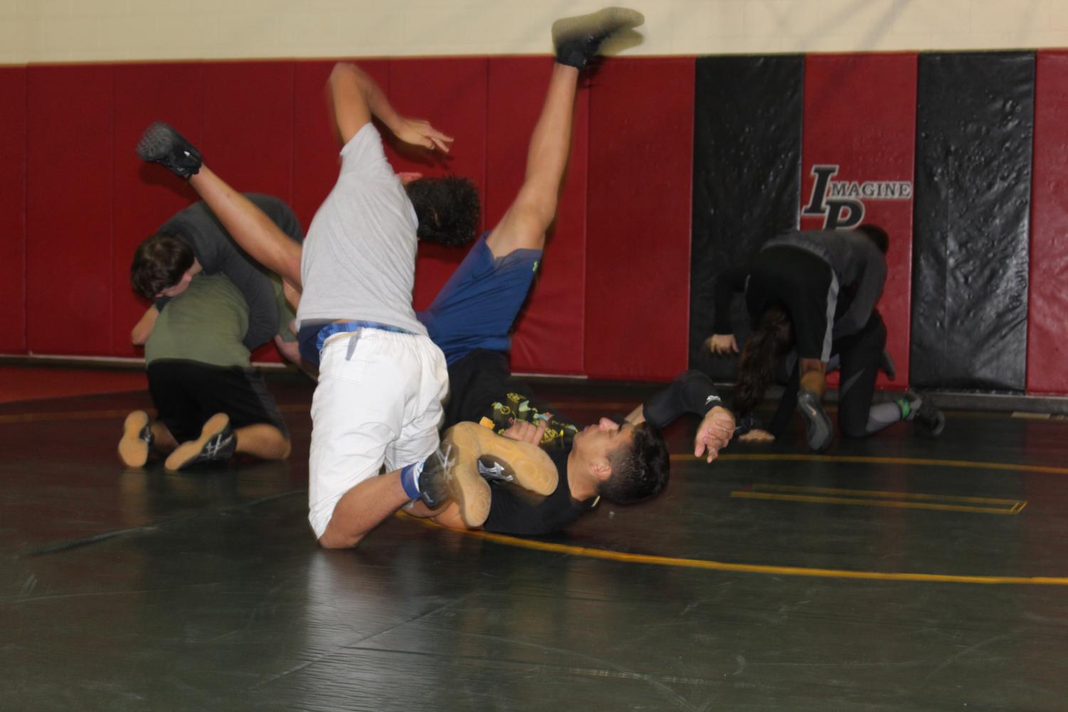 Sophomores Deshawn Newman, left, and Angel Acevedo III, right, practice their wrestling skills during early morning practice before school.